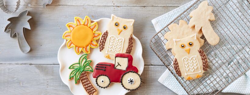 vegan sugar cookies on a white plate next to a cooling rack